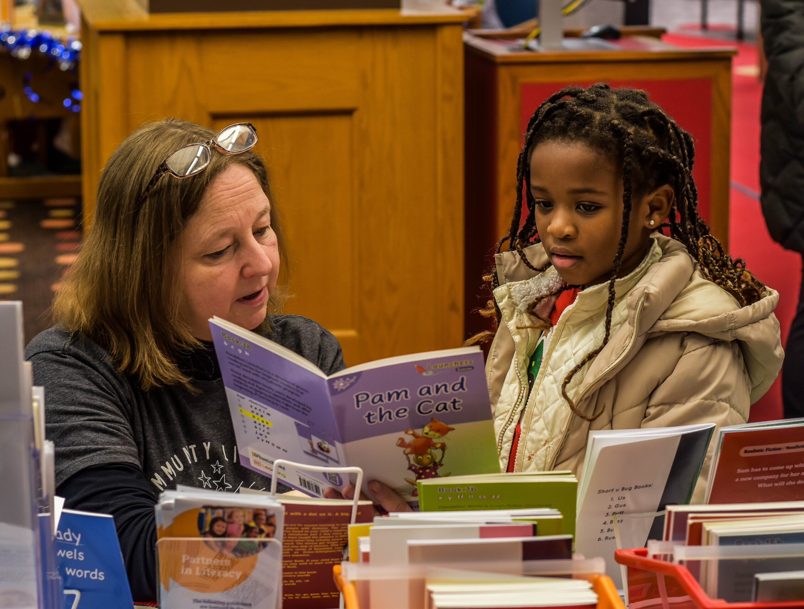Adult and child reading a decodable book together